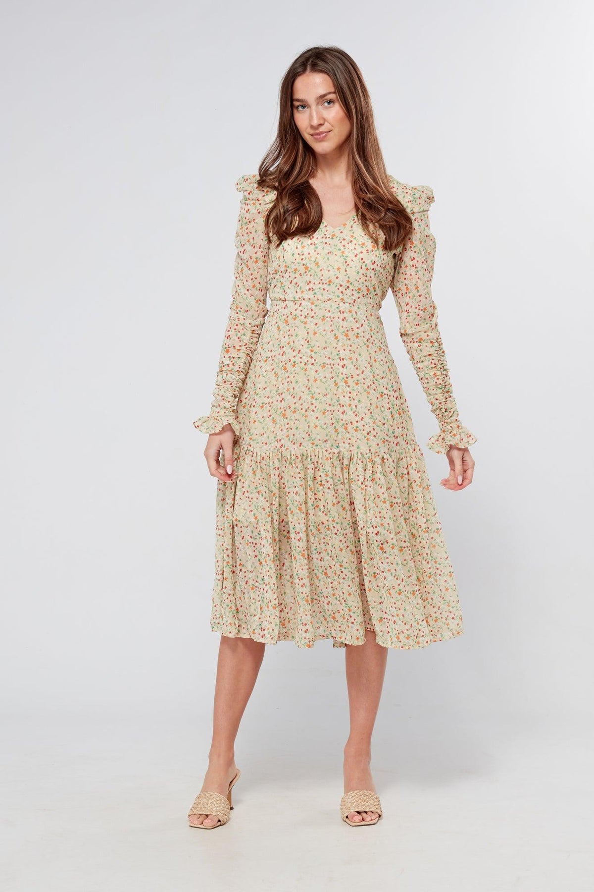 Introducing our Georgette beige floral midi dress, the perfect addition to your wardrobe for any special occasion. The dress features a stunning floral print on a beige georgette fabric that flows beautifully into a big frill. The design is nicely fitted on the waist and hips, creating a flattering silhouette, and then flowing into a frill for a feminine touch.