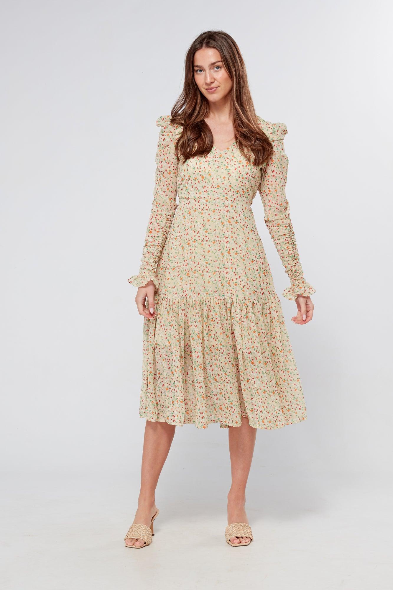 Introducing our Georgette beige floral midi dress, the perfect addition to your wardrobe for any special occasion. The dress features a stunning floral print on a beige georgette fabric that flows beautifully into a big frill. The design is nicely fitted on the waist and hips, creating a flattering silhouette, and then flowing into a frill for a feminine touch.