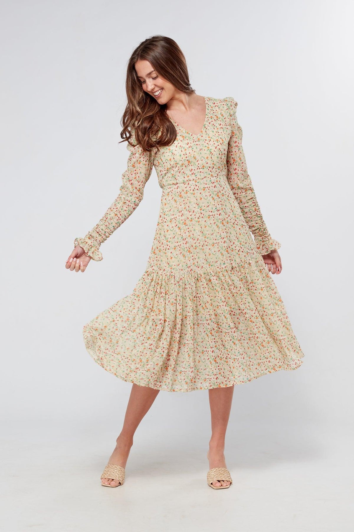 Introducing our Georgette beige floral midi dress, the perfect addition to your wardrobe for any special occasion. The dress features a stunning floral print on a beige georgette fabric that flows beautifully into a big frill. The design is nicely fitted on the waist and hips, creating a flattering silhouette, and then flowing into a frill for a feminine touch.