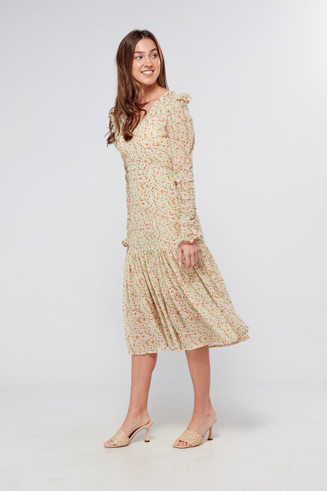 Introducing our Georgette beige floral midi dress, the perfect addition to your wardrobe for any special occasion. The dress features a stunning floral print on a beige georgette fabric that flows beautifully into a big frill. The design is nicely fitted on the waist and hips, creating a flattering silhouette, and then flowing into a frill for a feminine touch.