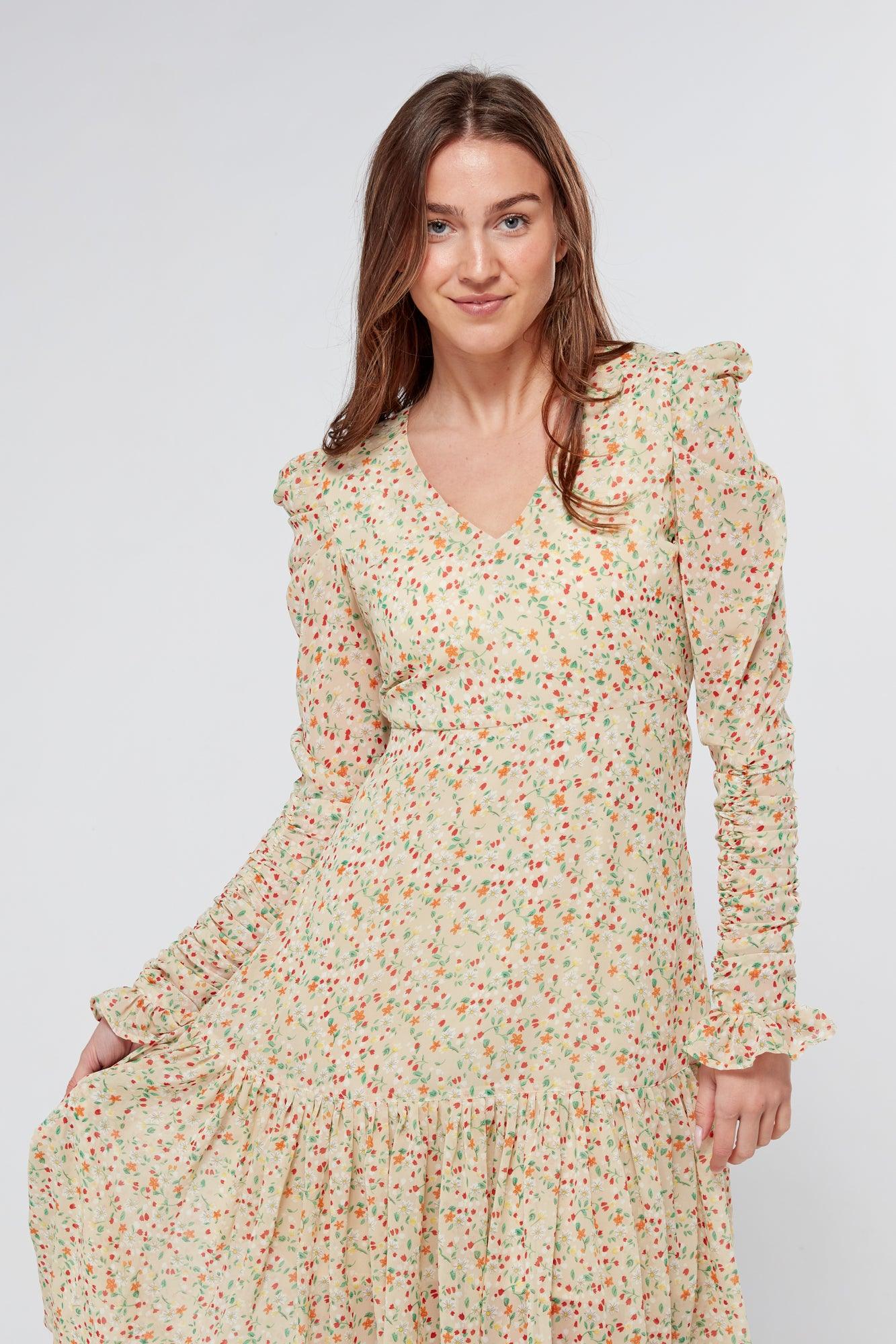 Introducing our Georgette beige floral midi dress, the perfect addition to your wardrobe for any special occasion. The dress features a stunning floral print on a beige georgette fabric that flows beautifully into a big frill. The design is nicely fitted on the waist and hips, creating a flattering silhouette, and then flowing into a frill for a feminine touch.